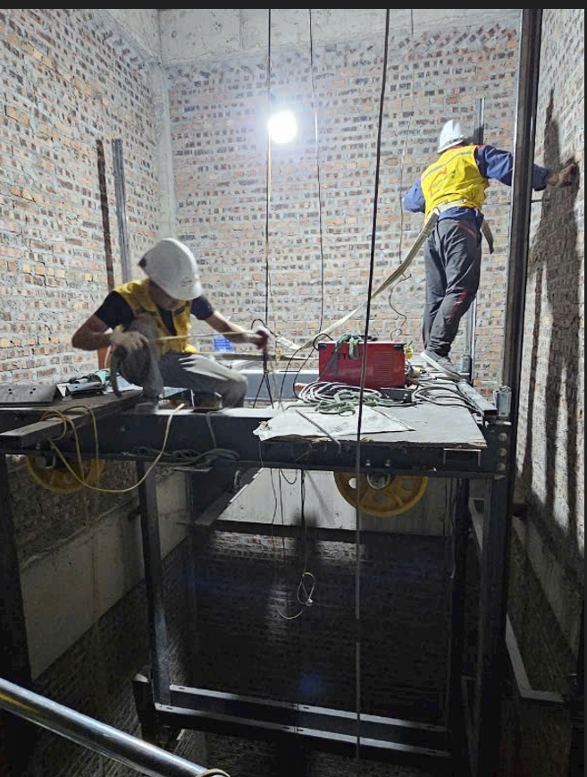 Elevator technicians are installing the mechanical and electrical systems inside the elevator shaft.