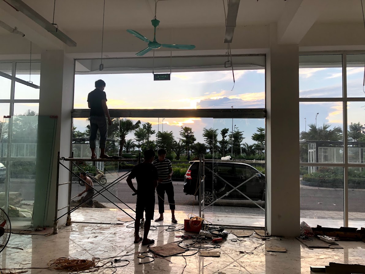 Thợ đang lắp đặt hệ kính cửa ra vào tại công trình