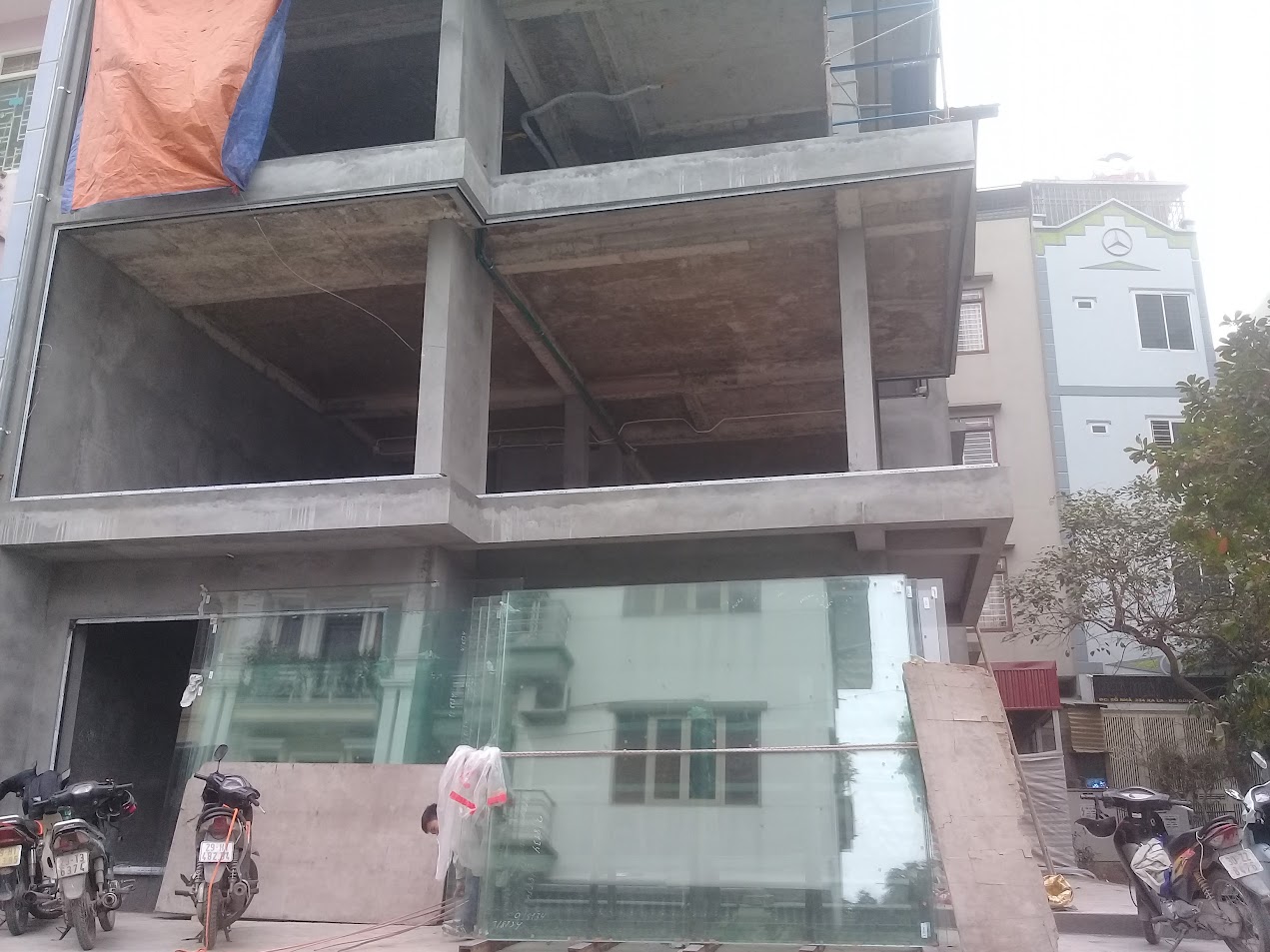 Tấm kính cường lực khổ lớn dựng trước công trình nhà phố đang xây dựng