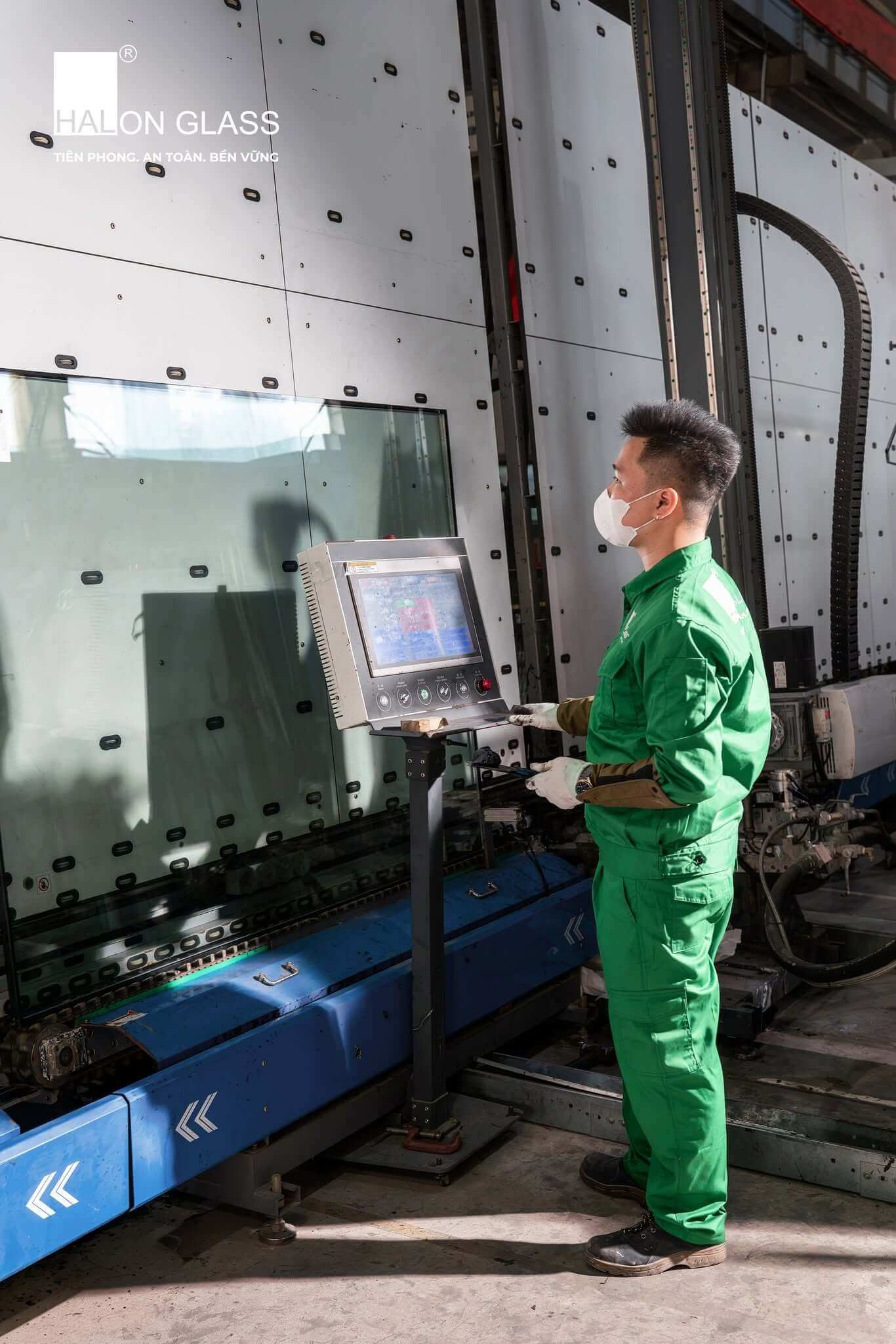 Nhân viên vận hành thiết bị gia công kính trong nhà máy