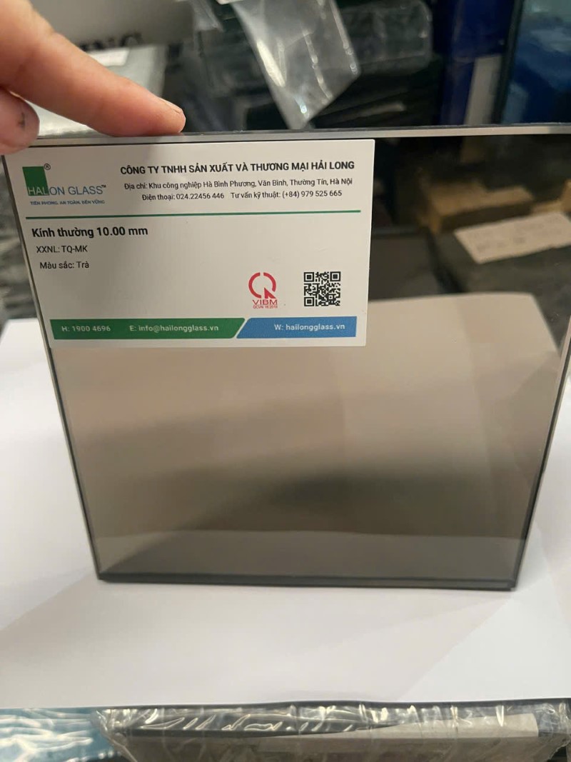 Tấm kính trà 10mm Hải Long Glass kèm tem thông tin sản phẩm đặt trên bàn trưng bày